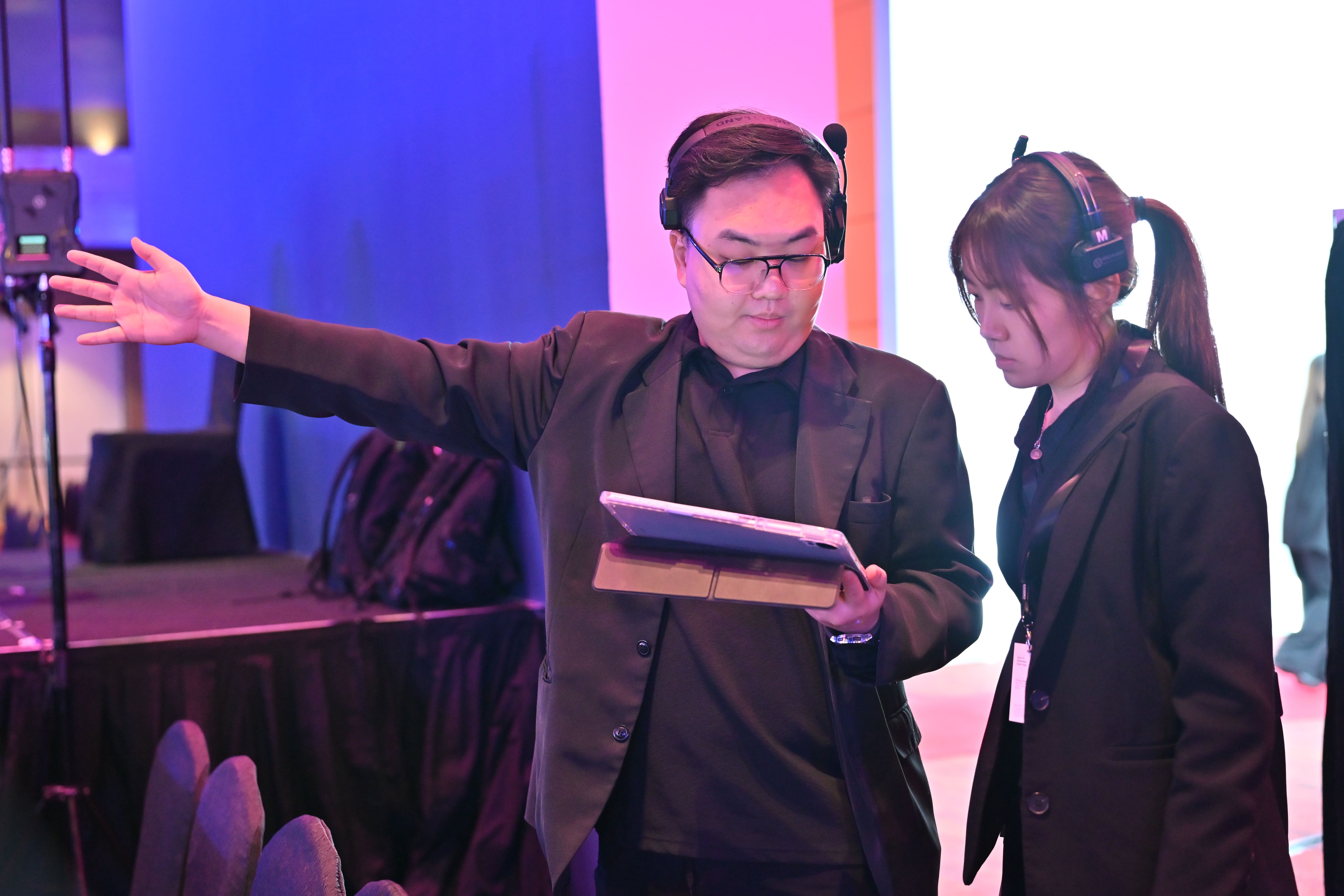 Event planner leading a pre-event team briefing for a major corporate conference in Malaysia