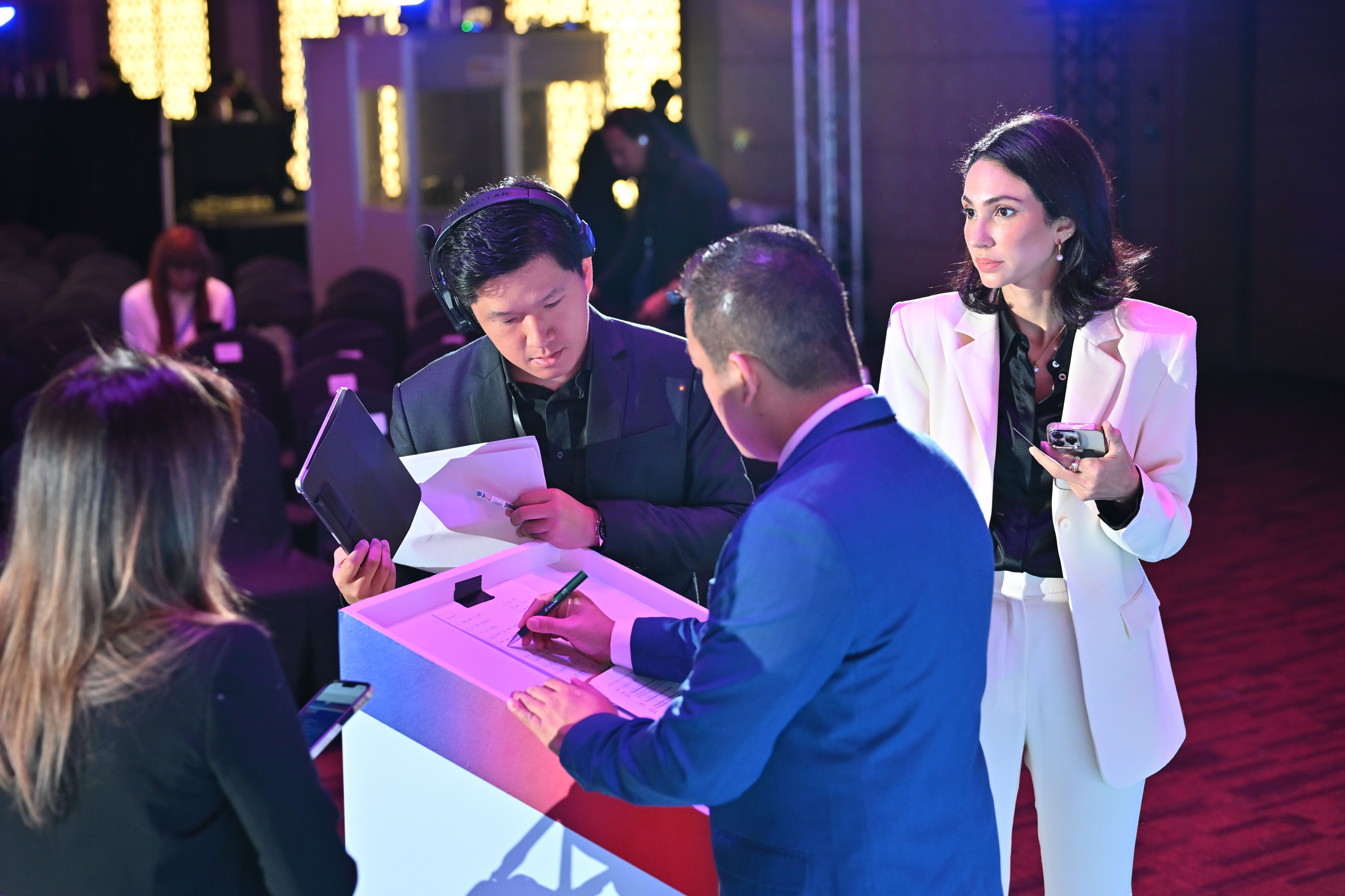 Event planner checking cue sheets during a corporate event rehearsal.